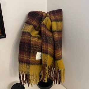 Detail of classic plaid scarf with long tassels and soft plush blend texture