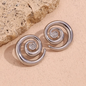 Macro view of silver spiral earrings featuring centered white zircon on rock texture