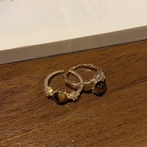Detail of 18k gold plated tiger eye stone rings with vintage texture and crystal accents