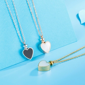 Three-color heart-shaped stainless steel pendant necklaces on a blue studio background
