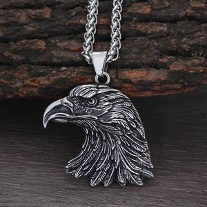 Vintage silver eagle pendant necklace for men with detailed feather engraving on wood background