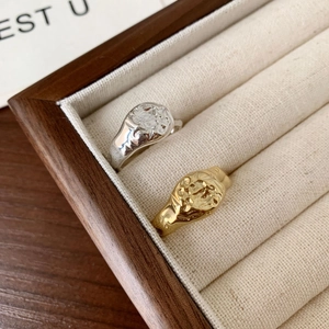 Detail of irregular textured gold and silver 925 sterling silver rings in a luxury tray