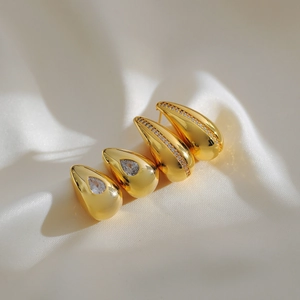 Elegant gold-plated waterdrop earrings with zircon inlays on a beige satin background