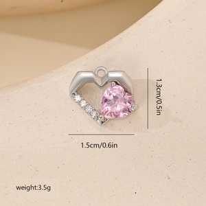 Macro view of heart pendant with pink gemstone and white cubic zirconia details