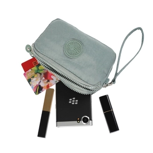 Internal detail of green nylon mobile pouch with three zip layers and storage capacity