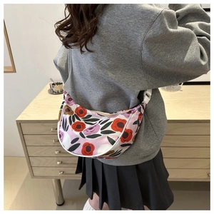 Detailed back view of a floral dumpling shoulder bag with adjustable strap on a model