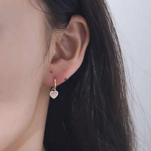 Chic gold heart drop earrings with pink enamel and zircon accents worn by model