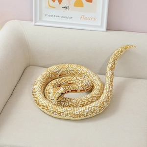 Detailed realistic plush snake toy with lifelike scale patterns on a cozy beige sofa