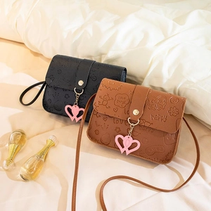 Chic embossed leather crossbody bag with heart pendant in black and brown colors