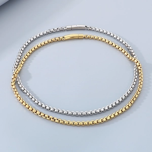 Detailed view of interlocked gold and silver stainless steel box chains with cylindrical clasps