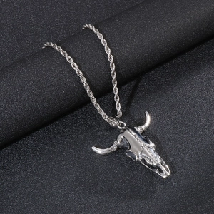 Detailed punk style bull skull pendant with rope chain on a black textured background