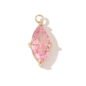 Macro shot of a marquise-cut pink gemstone pendant with gold setting and bail