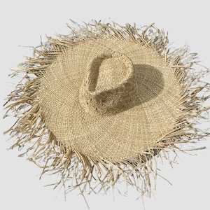 Sonnenhut aus natürlichem Raffia-Bast mit breiter Krempe und Fransenkante in Flatlay