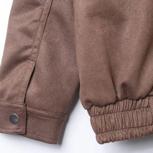 Detailed macro view of mocha brown suede jacket cuffs with button and elastic closure