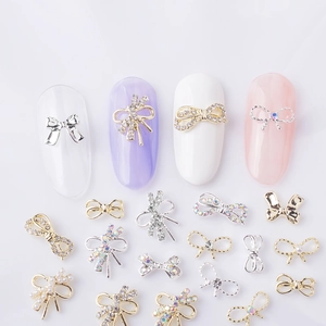 Macro view of 3D alloy bow nail charms with rhinestones and pearls for nail art