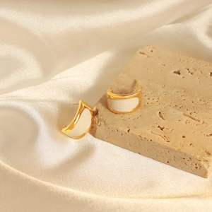 Elegant gold crescent earrings with creamy white enamel on a natural stone base