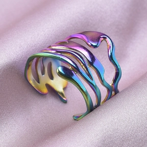 Irregular rainbow stainless steel ring detail on purple silk fabric background