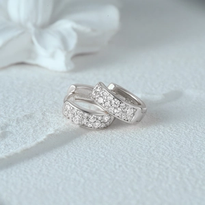 Close-up of minimalist S925 sterling silver huggie earrings with double row zircon pavé