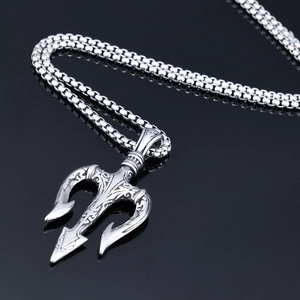 Macro shot of silver Viking trident pendant with intricate vintage engravings and box chain