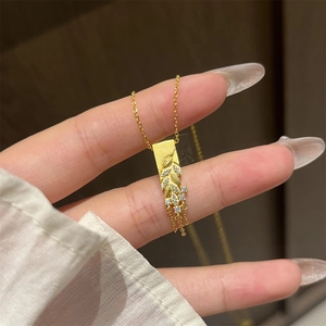 Macro shot of gold-plated pendant with sparkling zircon grapes and elegant tassels