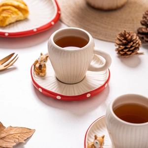 Macro detail of ceramic squirrel coffee cup with mushroom saucer set for cozy teatime