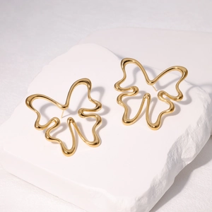 Minimalist golden hollow butterfly earrings in 304 stainless steel on a white stone