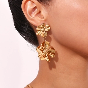 Fashionable 18K gold plated stainless steel double flower dangle earrings on a model
