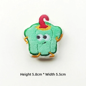 Detail of a green bell pepper plush pin with embroidery, size 5.8cm height and 5.5cm width