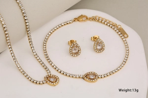 Detailed view of gold-plated tennis jewelry set with sparkling pear-shaped pendants