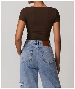 Close-up of brown slim-fit sports T-shirt back view paired with branded denim jeans