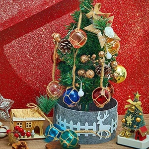 Colorful nautical glass float ball ornaments with rope netting on a Christmas tree