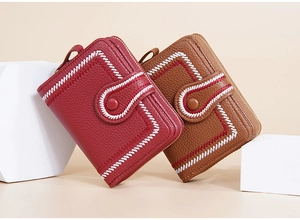 Detail of short wallets in burgundy and brown with stitch texture and metal zipper