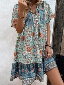 Detail of floral V-neck dress with buttons, light green boho style and ruffle hem