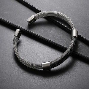 Detail of men's mesh steel and braided leather bracelet with silver accents