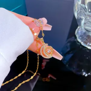 Détail macro du pendentif lune et cœur en or serti de zircons cubiques étincelants