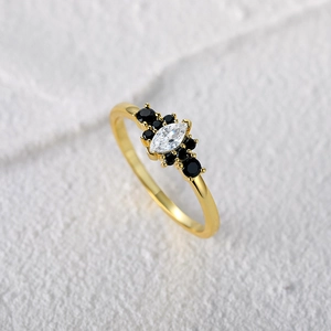 Macro shot of gold S925 silver ring featuring marquise opal and black spinel accents