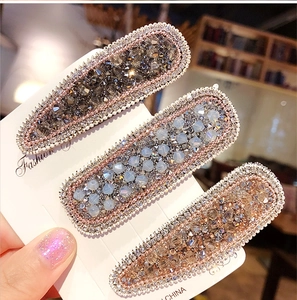 Close-up of sparkling rhinestone hair clips in grey, blue and champagne colors