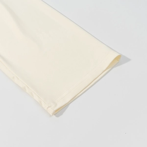 Primo piano del tessuto in maglia crema con cuciture fini e texture morbida sul polsino