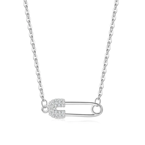 Macro detail of silver safety pin pendant with sparkling pave rhinestones and link chain
