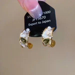 Elegant C-shaped earrings with olive green drop zircon and pearls on a gold finish