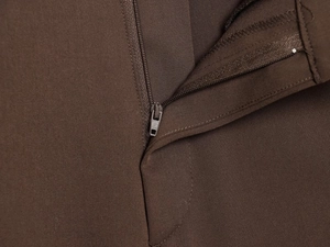 Close-up of brown houndstooth trousers showing the zipper and waistband details