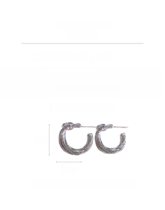 Detail showing dimensions and silver knotted texture of the round metal earring