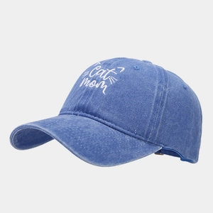 Detailed close-up of Cat Mom white embroidery on washed navy blue cotton baseball cap