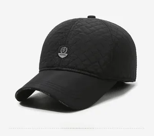 Detail of black quilted baseball cap with shield emblem and diamond pattern texture