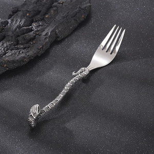 Macro shot of silver snake-shaped handle dinner fork with realistic scale textures