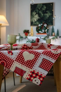 Close-up of red and black buffalo plaid tablecloth with beige heart and wooden button