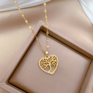 Detailed close-up of a heart-shaped tree of life pendant with sparkling crystals on silk