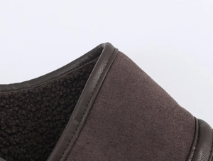Macro shot of warm chocolate brown suede boot with thick faux shearling lining and edge binding
