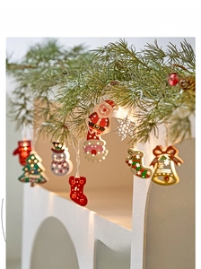 Close-up of LED Christmas string lights with Santa and snowman charms in warm glow