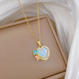 Detailed close-up of a heart pendant necklace with colorful inlay and butterfly accents